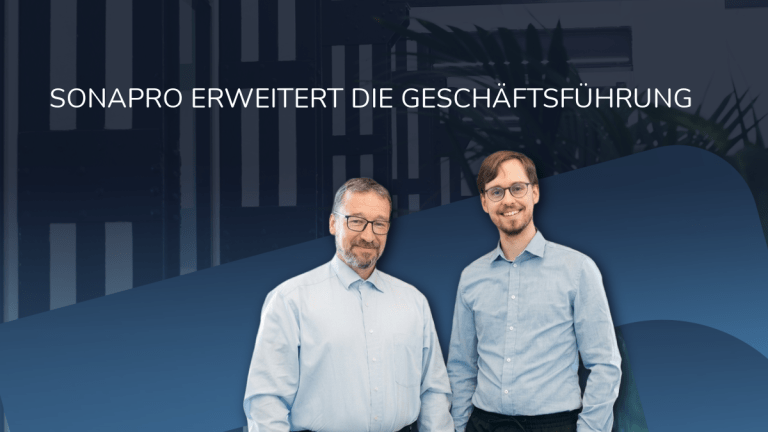 Das Bild zeigt zwei Männer in hellblauen Hemden vor einem blauen Hintergrund mit der großen Überschrift „SONAPRO ERWEITERT DIE GESCHÄFTSFÜHRUNG“.
