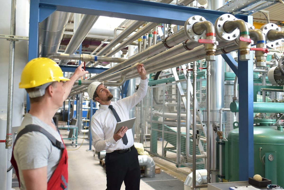 businessman and worker meeting in a factory - maintenance and repair of the industrial plant